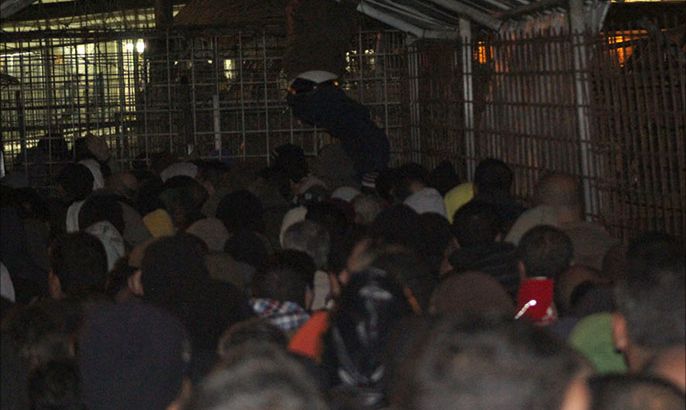 آلاف العمال يتكسدون على معبر الطيبة يوميا وبالصورة يظهر عامل يقفز من فوقهم من على ظهر المعبر امام الحراس الاسرائيليين