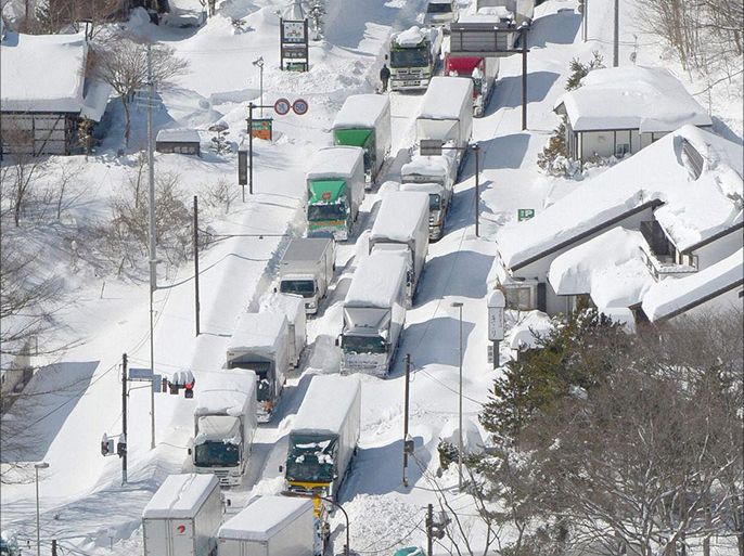Trucks and cars are stranded by heavy snow on a national road in Karuizawa in this February 16, 2014 picture provided by Kyodo. Heavy snow hit Tokyo and other parts of eastern Japan over the weekend, leaving 12 people dead, hundreds of thousands of households without electricity, and cau