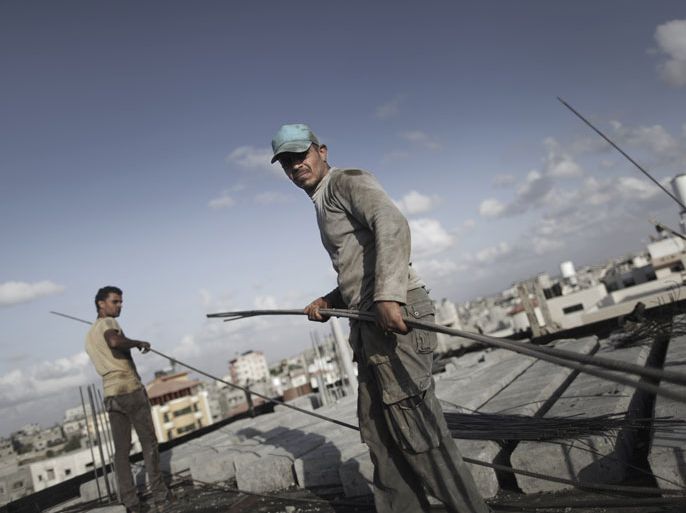 epa03873182 Palestinian workers prepare to pour cement on the roof of a high rise apartment building under construction in the Bait Lahyia town, northern Gaza Strip, 18 September 2013. According to media reports, Israel will permit limited quantities of construction materials for use by the private sector into Gaza Strip, for the first time since 2007, starting from 22 September. EPA/ALI ALI
