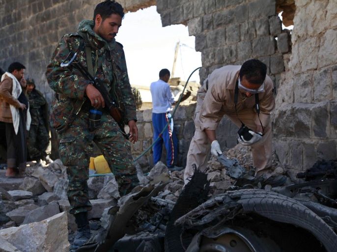 Investigators from the criminal investigation department (CID) examine the wreckage of a car after a bomb exploded outside the main wall of the central prison in Sanaa February 14, 2014. Eleven people were killed when attackers mounted a bomb, grenade and gun assault on the main prison in Yemen's capital on Thursday to try to free inmates, security sources and witnesses said. Explosions and gunfire could be heard several kilometres away from the prison in northern Sanaa, which has al Qaeda members among its inmates. The biggest explosion rattled windows in the area. REUTERS/Mohamed al-Sayaghi (YEMEN - Tags: CIVIL UNREST POLITICS)