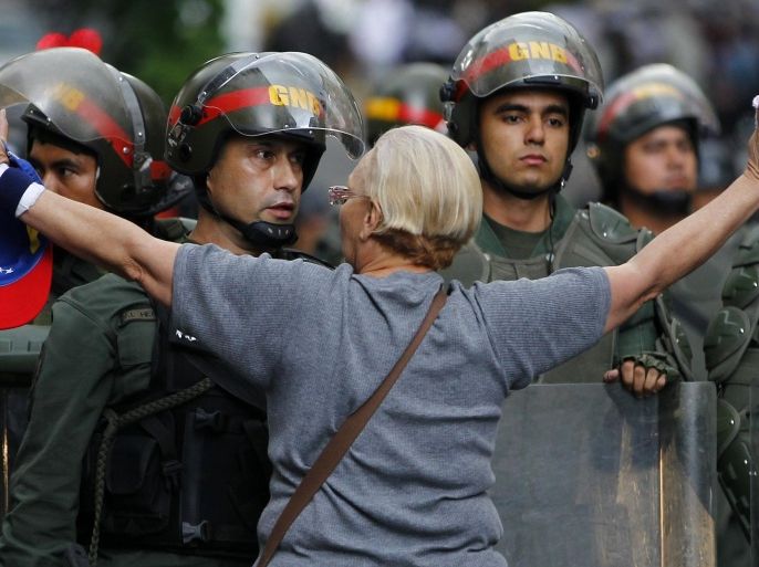 An opposition supporter shouts at a riot police officer during a protest against President Nicolas Maduro's government in Caracas February 17, 2014. Venezuela ordered the expulsion of three U.S. diplomats on Monday on charges of recruiting university students to lead demonstrations that have left three dead in the OPEC nation's most serious violence since President Nicolas Maduro's election in April. REUTERS/Carlos Garcia Rawlins (VENEZUELA - Tags: POLITICS CIVIL UNREST TPX IMAGES OF THE DAY BUSINESS)
