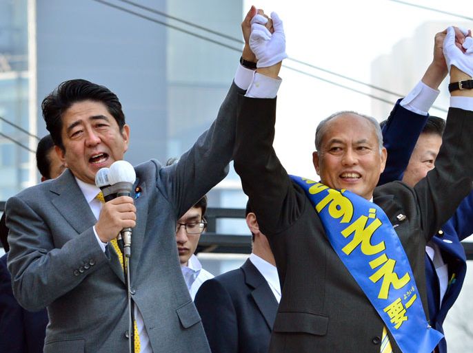 (FILES) This file picture taken on February 2, 2014 shows Japanese Prime Minister and the ruling Liberal Democratic Party (LDP) President Shinzo Abe (L) delivering a speech to support former health minister and current candidate for the Tokyo gubernatorial election Yoichi Masuzoe (R) during Masuzoe's election campaign in Tokyo. Newspaper surveys suggest one-time television presenter and former cabinet minister Masuzoe has a commanding lead, despite his alignment with the government on the need to restart Japan's idled nuclear reactors. AFP PHOTO