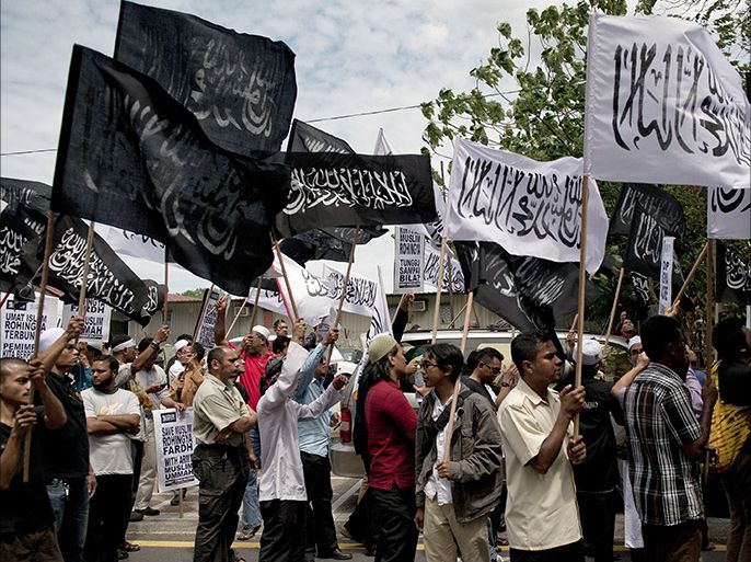Malaysian Muslim activists carry flags during a peaceful protest against the persecution of Rohingya Muslims in Myanmar