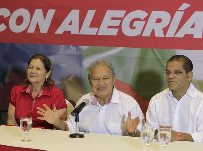 epa04053243 Salvador Sanchez Ceren (C) presidential candidate of the ruling party, the Farabundo Marti National Liberation Front (FMLN), speaks next to his wife, Margarita Villalta (L) and vice presidential running mate, Oscar Ortiz (R), during a press conference in San Salvador, El Salvador, 02 February 2014. Ceren proclaimed his victory in the elections in El Salvador, but acknowledged that the preliminary official results forced him to go to a second round with Norman Quijano, presidential candidate of the opposition party Nationalist Republican Alliance (ARENA). EPA/Roberto Escobar
