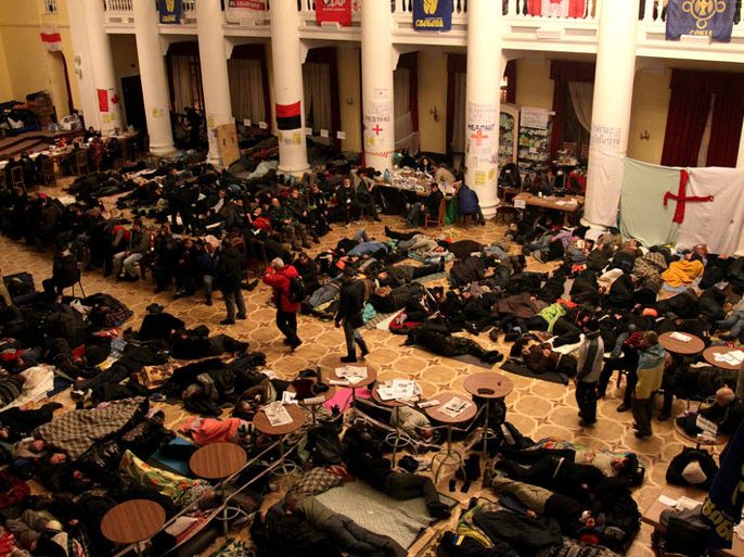 epa03989944 Ukrainian pro-European protestors sleep inside Kiev's City Hall in Kiev, Ukraine, 14 December 2013. Ukrainian President Viktor Yanukovych and leaders of Ukrainian opposition participated in a round table event to discuss public proposals aimed at achieving political stability, public peace and tranquility in Ukraine. The mass demonstrations in Kiev continued, with up to 20,000 anti-government protesters reinforcing barricades, emboldened by police assurances that they would not be cleared by force. Protesters leaders vowed to continue the protests until President Viktor Yanukovych will step down calling for new elections. EPA/ZURAB KURTSIKIDZE