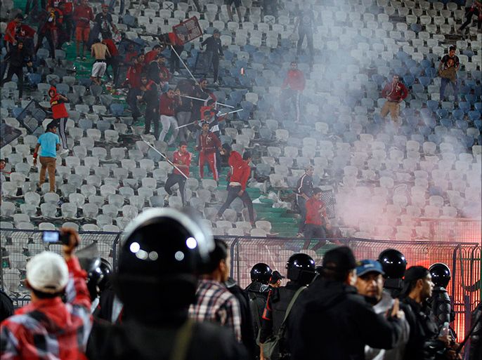 Fans of Egypt's Al-Ahly, known as "Ultras", flee after riot police fired tear gas during clashes after their African Super Cup soccer match against Tunisia's CS Sfaxien at Cairo Stadium February 20, 2014. Al-Ahly won the African Super