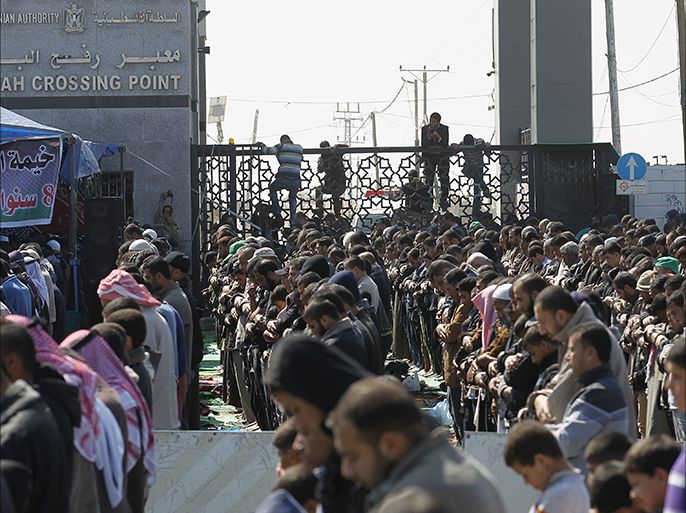 Palestinians pray near the gate of the Rafah border crossing with Egypt on February 28, 2014, during a protest to demand that Egypt lift border crossing restrictions. Egypt imposed the restrictions as part of a campaign by its security forces against jihadists in the lawless Sinai Peninsula, which borders Gaza and Israel