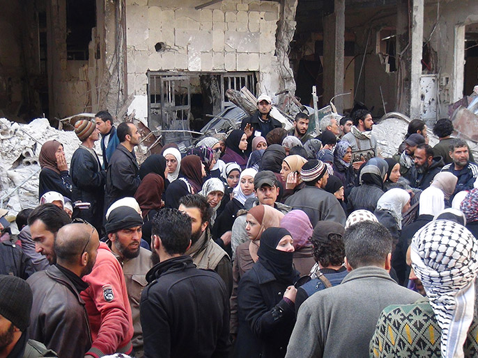 تجمع لسكان مخيم اليرموك في انتظار توزيع المساعدات (الجزيرة-أرشيف)