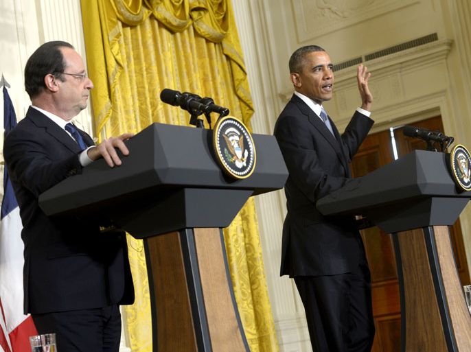 epa04070271 US President Barack Obama (R) listens as French President Francois Hollande (L) responds to a question during a joint press conference in the East Room of the White House in Washington, DC, USA, 11 February 2014