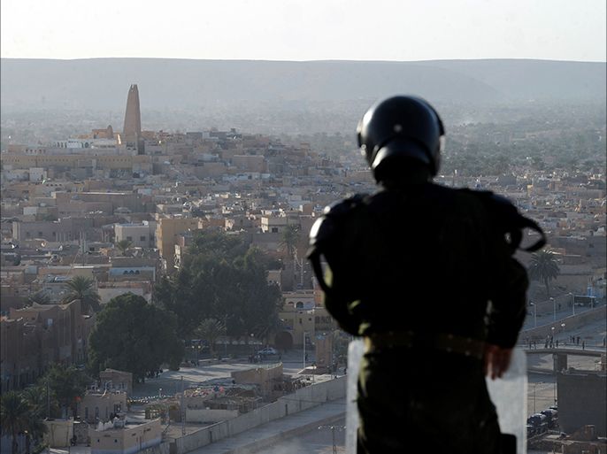 A member of the Algerian security forces stands guard on a ridge looking down on the Algerian city of Ghardaia on March 18, 2014 during an operation to secure the city following sectarian clashes. The city of 90,000 inhabitants has been rocked since December by clashes between the Chaamba community of Arab origin and the majority Mozabites, indigenous Berbers belonging to the Ibadi Muslim sect. AFP PHOTO / FAROUK BATICHE
