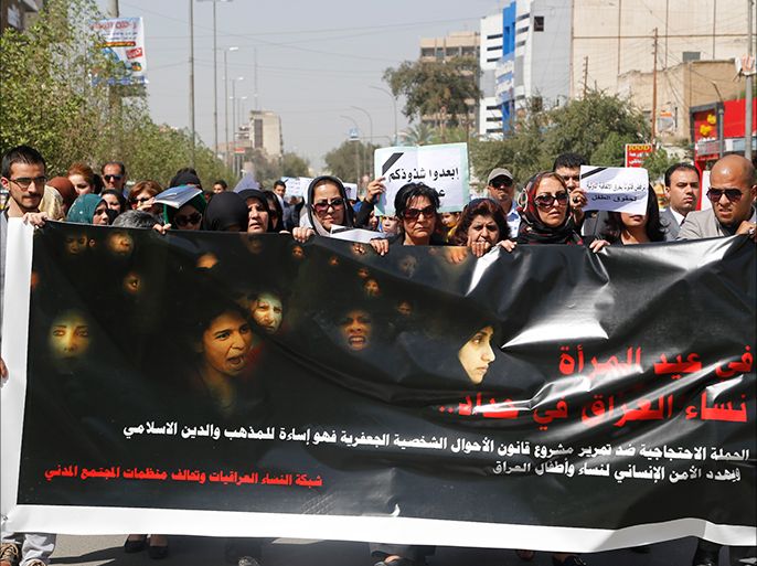 Iraqi Protesters hold a banner during a demonstration against the draft of the "Al-Jafaari" Personal Status Law during International Women's Day in Baghdad March 8, 2014. Protesters say the law, which involves the use of Shi'ite Jafaari law with regards to divorce, marriage and inheritance, will restrict their personal rights, according to local media. On March 8 activists around the globe celebrate International Women's Day, which dates back to the beginning of the 20th Century and has been observed by the United Nations since 1975. The UN writes that it is an occasion to commemorate achievements in women's rights and to call for further change. The banner reads, "The campaign of protest against the Passing of the code of Jaafari Personal Status is the abuse of the doctrine of the Islamic religion and threatens human security for women and children of Iraq". REUTERS/Thaier al-Sudani (IRAQ - Tags: SOCIETY POLITICS ANNIVERSARY)