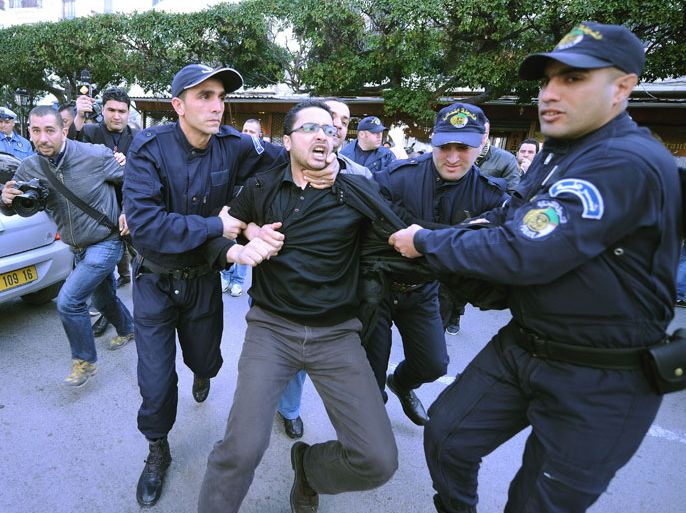 FB03 - Algiers, -, ALGERIA : An Algerian is arrested by policemen during a protest outside the constitutional council in Algiers on March 6, 2014, against the bid by Algerian President Abdelaziz Bouteflika to run for a fourth term in the up coming April 17 national elections. Bouteflika, who helped end Algeria's devastating 1990s civil war but whose recent rule has been dogged by corruption scandals, told Algerian television on March 3 that he had registered as a candidate for reelection. AFP PHOTO/FAROUK BATICHE
