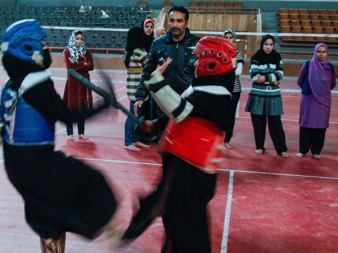 SRINAGAR, KASHMIR, INDIA - DECEMBER 16: Mohammad Iqbal a martial art coach teaches Kashmiri Muslim girls Thang-ta, martial arts inside indoor stadium on December 16, 2013 in Srinagar, the summer capital of Indian administered Kashmir, India. As the number of crimes against women has risen in the region, girls from different age groups and backgrounds have taken up martial arts and other self defence courses to thwart attackers. Many believe after the barbaric rape and murder of a para-medic student last year on this day in the Indian capital of New Delhi, women in the Muslim majority state have taken to various martial arts forms like Thang-ta, a weapon-based Indian Martial art for protection.