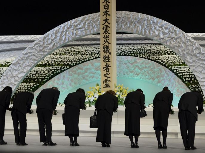 Relatives of victims of the March 11, 2011 earthquake and tsunami bow to the altar as they offer chrysanthemums for the victims at the national memorial service in Tokyo March 11, 2014. Tuesday marks the third-year anniversary of the March 11, 2011 earthquake and tsunami that killed thousands and set off a nuclear crisis. REUTERS/Franck Robichon/Pool (JAPAN - Tags: ANNIVERSARY DISASTER ROYALS)