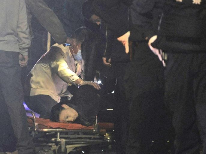 CORRECTS ID OF THE BODY - The body of an assailant is inspected by police officers outside a railway station, after an attack by knife wielding men left scores of people dead in Kunming, in southwestern China's Yunnan province, Saturday March 1, 2014. China's official Xinhua News Agency says authorities consider the attack by a group of knife-wielding assailants at a train station in southwestern China in which scores of people died and over 100 were injured, to be an act of terrorism. (AP Photo) CHINA OUT