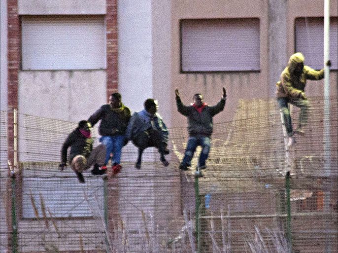 Would be immigrants jump over a fence into the north African Spanish enclave of Melilla on February, 28, 2014. More than 200 migrants stormed across a triple-layer border fence into Melilla today, Spanish authorities said, in one of the largest such crossings in years. Some 300 people launched the dawn assault to cross into the Spanish city, which lies on the northern tip of Morocco, and 214 made it across. AFP PHOTO / BLASCO DE AVELLANEDA