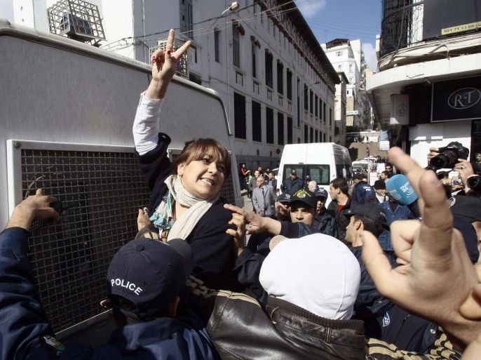 A protester gestures as she is detained by police during a demonstration against Algerian President Abdulaziz Bouteflika's decision to run for a fourth term, in Algiers March 6, 2014. Bouteflika on Monday formally registered his candidacy for April's election, one of the few times the aging independence veteran has spoken in public since suffering a stroke last year. REUTERS/Ramzi Boudina (ALGERIA - Tags: CIVIL UNREST POLITICS ELECTIONS CRIME LAW)