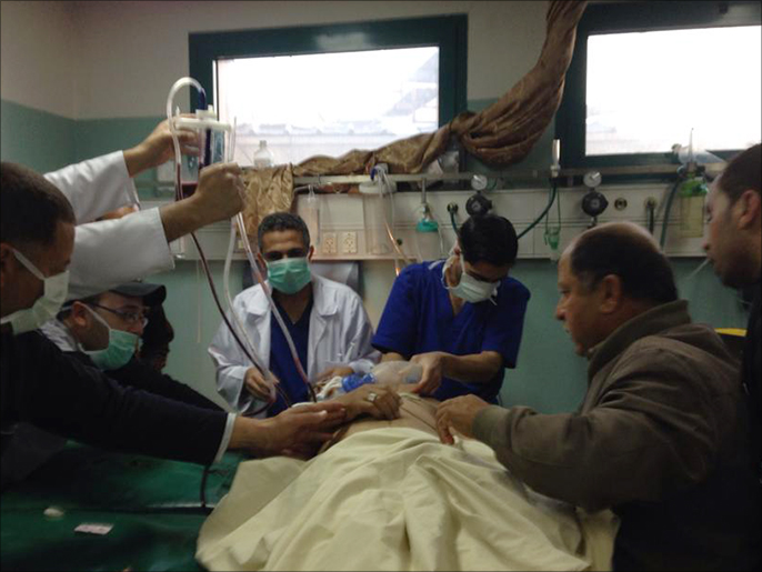 مسعفون يحاولون إنعاش مصاب برصاص القناصة الإسرائيليين (الجزيرة)