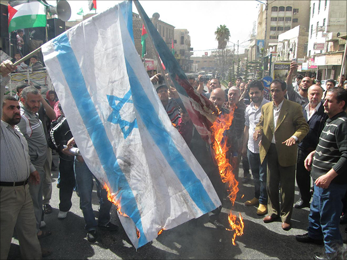 ‪متظاهرون يحرقون علم إسرائيل‬ (الجزيرة نت)