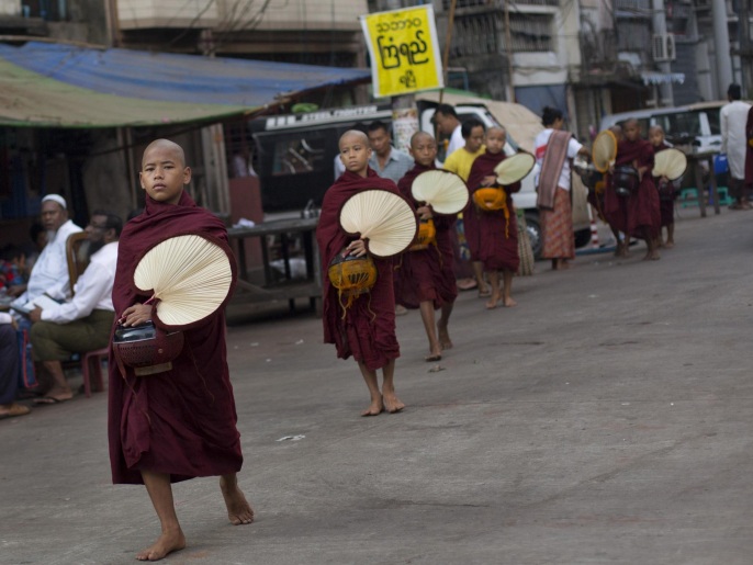 ‪‬ رهبان بوذيون يتجولون بأحد أحياء الروهينغا برانجون اليوم(أسوشيتد برس)