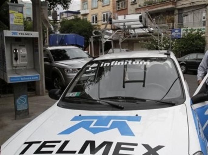In this photo taken June 29, 2011, a TELMEX phone company repair worker gets into his company car in Mexico City. Television magnates and the cell phone and telephone companies owned by Mexican billionaire Carlos Slim are fighting for the prize known as the "triple play:" a single company supplying cell and fixed-line phones, TV and internet service to consumers. Whoever wins that market holds a key into the homes of 112.7 million Mexican consumers.