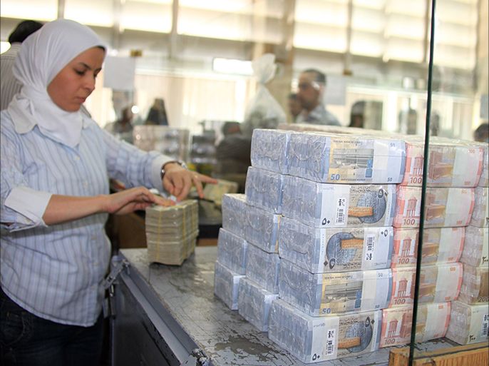 epa02262779 A bank official packs up the three new Syrian banknotes, 50, 100, 200 pounds, which have been put into circulation by the Central Bank of Syria on 27 July 2010 in Damascus, Syria