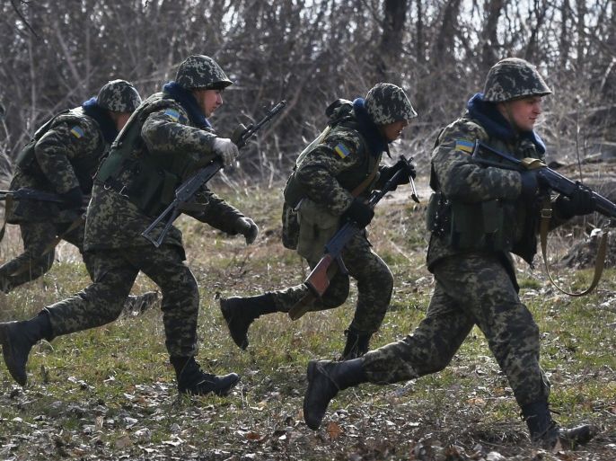 Ukrainian border guards run to take their positions during training at a military camp in the village of Alekseyevka on the Ukrainian-Russian border, eastern Ukraine, Friday, March 21, 2014. Russian President Vladimir Putin has signed a resolution approved by parliament to annex Crimea. Putin also says there is no need for further Russian action against the West beyond some individual sanctions announced yesterday. (AP Photo/Sergei Grits)