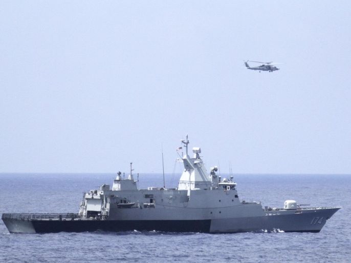 The Royal Malaysian Navy corvette KD Terengganu and a U.S. Navy MH-60R Sea Hawk helicopter from the US Navy guided-missile destroyer USS Pinckney conduct a coordinated air and sea search for a missing Malaysian Airlines jet in the Gulf of Thailand March 12, 2014. Malaysia Airlines Flight MH370, with 239 people on board, dropped off air traffic control screens at about 1:30 a.m. on March 8, 2014, less than an hour into a flight from Kuala Lumpur to Beijing. There were no reports of bad weather or mechanical problems. Picture taken March 12, 2014. REUTERS/Operations Specialist 1st Class Claudia Franco/US Navy/Handout via Reuters (UNITED STATES - Tags: MILITARY TRANSPORT DISASTER) FOR EDITORIAL USE ONLY. NOT FOR SALE FOR MARKETING OR ADVERTISING CAMPAIGNS. THIS IMAGE HAS BEEN SUPPLIED BY A THIRD PARTY. IT IS DISTRIBUTED, EXACTLY AS RECEIVED BY REUTERS, AS A SERVICE TO CLIENTS
