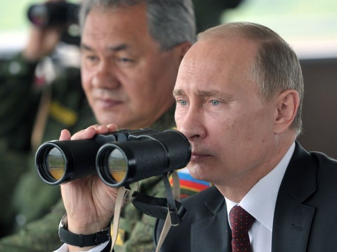 FILE - In this Tuesday, July 16, 2013 file photo Russian President Vladimir Putin, flanked by Defense Minister Sergei Shoigu, uses binocular as he watches military exercise near Yuzhno-Sakhalinsk, on Sakhalin Island, Russia. President Vladimir Putin on Wednesday, Feb. 26, 2014, ordered massive exercises involving most of its military units in western Russia amid tensions in Ukraine. (AP Photo/RIA Novosti, Alexei Nikolsky, Presidential Press Service, Pool)