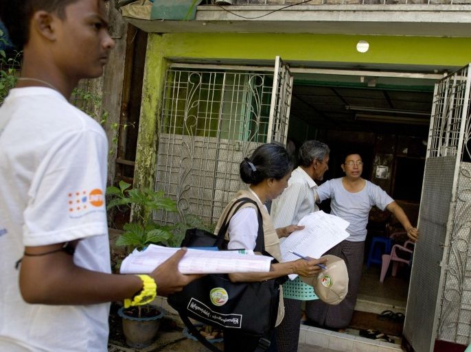 A Myanmar census enumerator and volunteers enter a house to collect information in Yangon, Myanmar, Sunday, Mar 30, 2014. Enumerators fanned out across Myanmar on Sunday for a census that has been widely criticized for stoking religious and ethnic tensions, after the government denied members of a long-persecuted Muslim minority the right to identify themselves as "Rohingya." (AP Photo/Gemunu Amarasinghe)