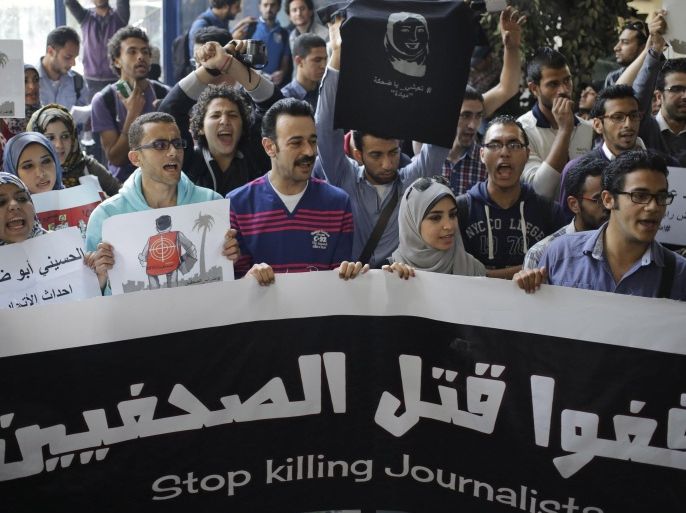 Egyptian journalists shout slogans during a protest at the journalists syndicate in Cairo, Egypt, Friday, April 4, 2014. Dozens of of writers and photographers held a one-day strike calling for the security forces to protect journalists who cover protests and calling for their employers to provide them with protections when covering violent events. The strike came a week after a journalist was killed in Egypt, while covering clashes. The Arabic on the banner reads, "Stop killing journalists." (AP Photo/Amr Nabil)