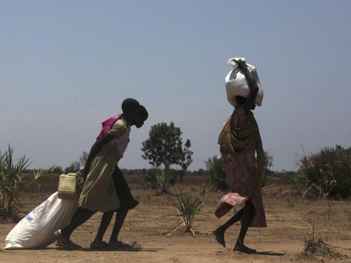 Women carry food at a food distribution site in Nyal, Unity State, April 1, 2014. REUTERS/Andreea Campeanu
