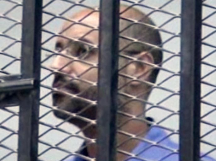 This image made from AP video shows Seif al-Islam Gadhafi, son of Libya's former dictator Moammar Gadhafi, inside a cage in a courtroom in Zintan, Libya, Thursday, Sept. 19, 2013. A militia-run prison failed to transfer Gadhafi to a pre-trial hearing in Tripoli on Thursday, underscoring the central government’s difficulty in asserting its authority since the end of the country’s civil war.(AP Photo via AP video)