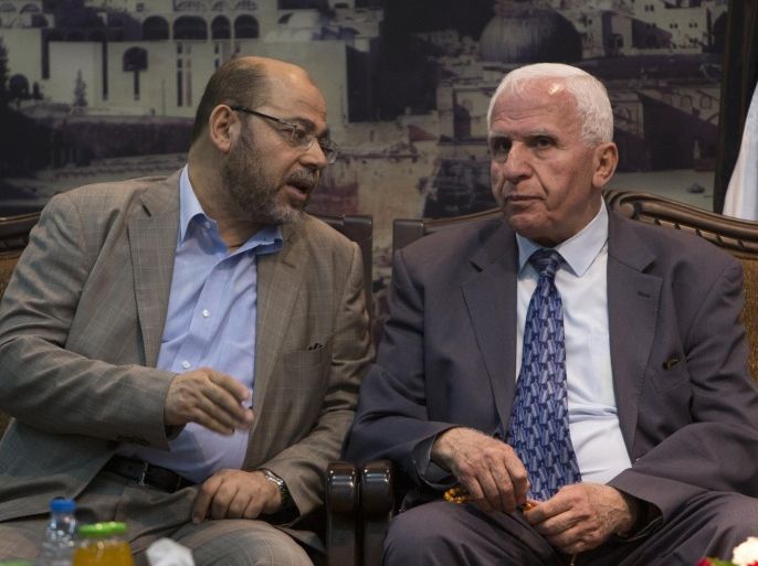 Hamas deputy leader Musa Abu Marzuk (L) speaks with the head of the delegation of the Palestine Liberation Organisation (PLO) Azzam al-Ahmad, a senior figure in the mainstream Fatah party of president Mahmud Abbas, during a meeting in Gaza City on April 22, 2014. The Palestinians have relaunched efforts to reconcile their rival leaderships in the West Bank and Gaza Strip as US-brokered peace talks with Israel teeter on the edge of collapse. AFP PHOTO /MAHMUD HAMS