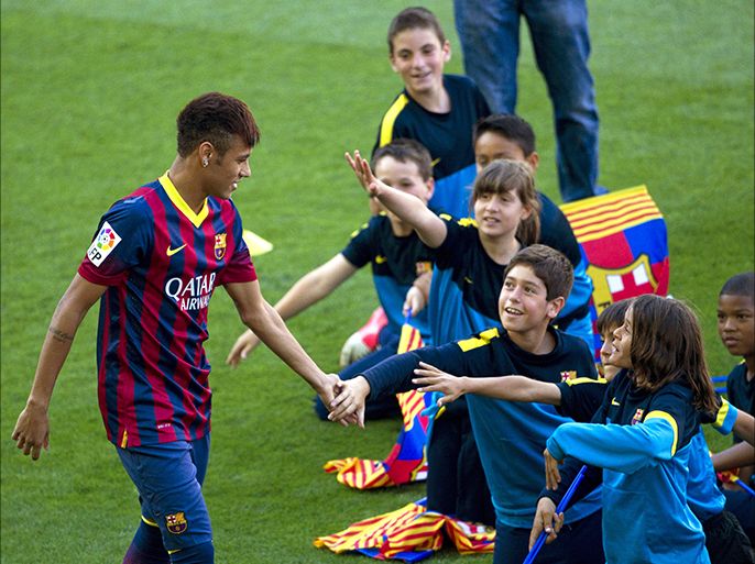epa03729632 Brazilian forward Neymar (L) greets children during his presentation as new player of FC Barcelona at the team's facilities in Barcelona, northeastern Spain, 03 June 2013
