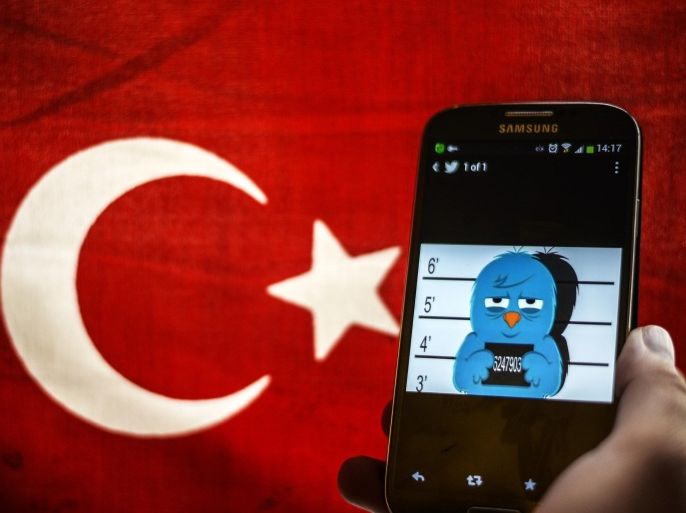 A picture representing a mugshot of the twitter bird is seen on a smart phone with a Turkish flag on March 26, 2014 in Istanbul. A Turkish court on Wednesday overturned the government's controversial Twitter ban imposed after audio recordings spread via the social media site implicated Prime Minister Recep Tayyip Erdogan in a corruption scandal. AFP PHOTO / OZAN KOSE