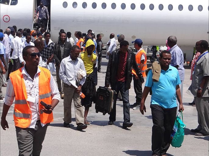 المرحلون من اللاجئين الصوماليين لحظة وصولهم إلى مطار مقديشو الدولي الأربعاء