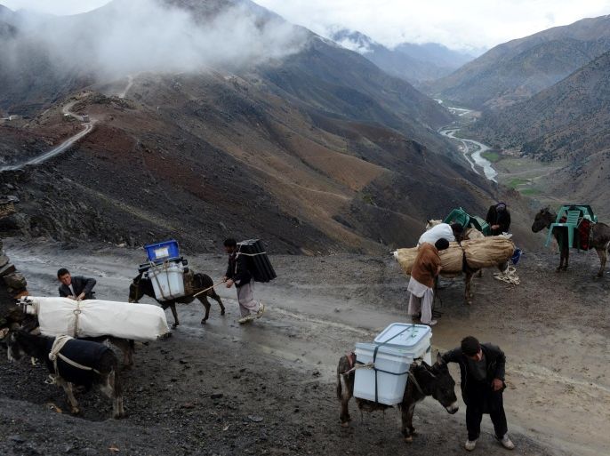 Afghan villagers strap election materials to donkeys as they head back to their village along a country road high in the mountains of Shutul District in northern Afghanistan on April 4, 2014. Afghans will vote on April 5 in the country's third presidential election to choose a successor to Hamid Karzai, who has led the country since the fall of the Taliban in 2001. AFP PHOTO/SHAH MARAI