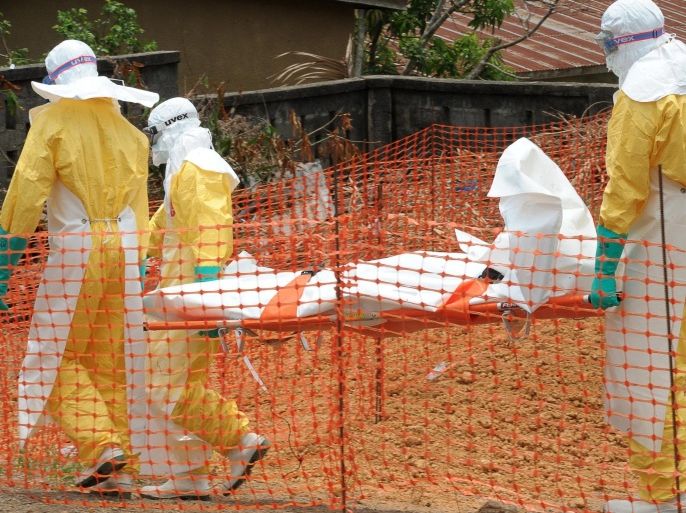 Staff of the 'Doctors without Borders' ('Medecin sans frontieres') medical aid organisation carry the body of a person killed by viral haemorrhagic fever, at a center for victims of the Ebola virus in Guekedou, on April 1, 2014. The viral haemorrhagic fever epidemic raging in Guinea is caused by several viruses which have similar symptoms -- the deadliest and most feared of which is Ebola. AFP PHOTO / SEYLLOU