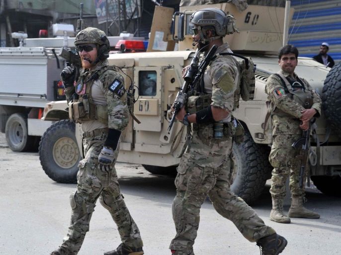 International Security Assistance Force (ISAF) troops and Afghan forces inspect the scene of an attack on a bank in the eastern Afghan province of Kunar on March 25,2014. Fifteen people died in violence around Afghanistan less than a fortnight before the country's presidential poll.The insurgents have vowed a campaign of violence to disrupt the ballot on April 5, urging their fighters to attack polling staff, voters and security forces in the run-up to election day.AFP PHOTO/ Noorullah Shirzada
