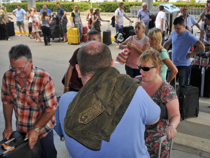 سياح بريطانيون يصطفون بمطار مومباسا استعداداً لمغادرة المدينة (أسوشيتد برس)