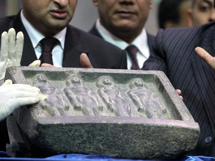 An Egyptian archaeologist shows a Pharaonic artifact that was stolen from the Egyptian Museum since the revolution of January 2011 during a press conference at Cairo airport in Cairo,Egypt on 03 May 2014. Germany returned three Pharaonic pieces that were stolen since the revolution of January 2011.