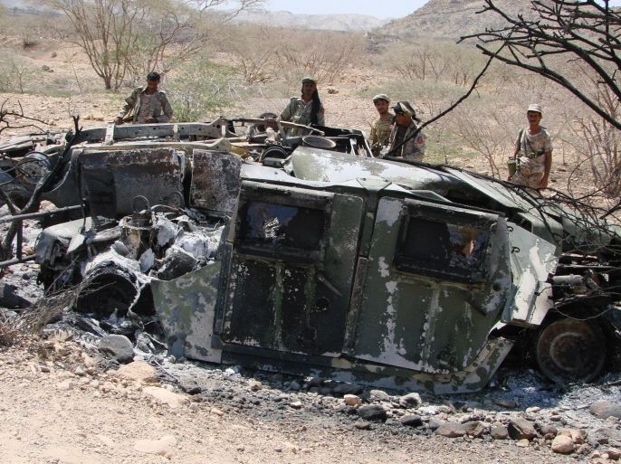 In this Friday, May 1, 2014, photo provided by Yemen's Defense Ministry, soldiers inspect the wreckage of vehicles destroyed during fighting with al-Qaida militants in Majala of the southern province of Abyan, Yemen. (AP Photo/Yemen's Defense Ministry)