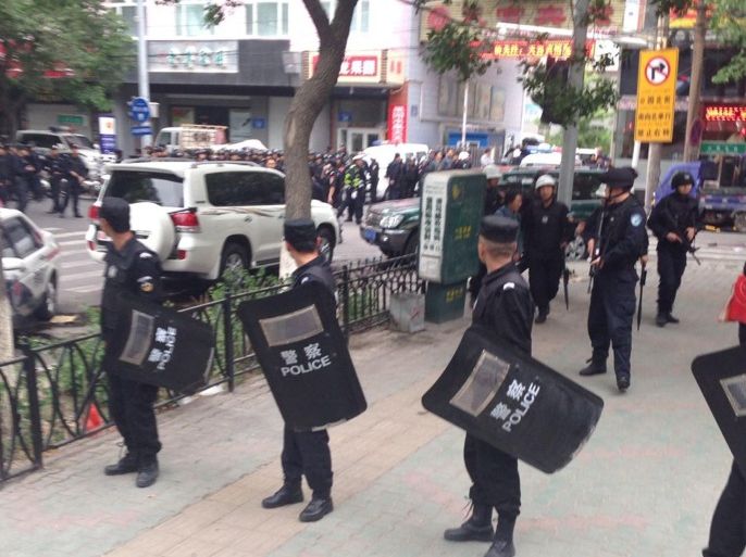 In this photo released by China's Xinhua News Agency, police officers stand guard near a blast site which has been cordoned off, in downtown Urumqi, capital of northwest China's Xinjiang Uygur Autonomous Region, Thursday, May 22, 2014. Attackers crashed a pair of vehicles and tossed explosives in an attack Thursday near an open air market in the capital of China's volatile northwestern region of Xinjiang, leaving an unknown number of people dead and injured, state media reported. (AP Photo/Cao Zhiheng)