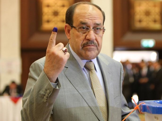 Iraqi Prime Minister Nuri al-Maliki shows his ink-stained finger after casting his vote in Iraq's first parliamentary election since US troops withdrew at a polling station in Baghdad's al-Rashid hotel, in the fortified Green Zone of the capital, on April 30, 2014 . Iraqis streamed to voting centres nationwide, amid the worst bloodshed in years, Maliki seeks reelection. AFP PHOTO / ALI AL-SAADI