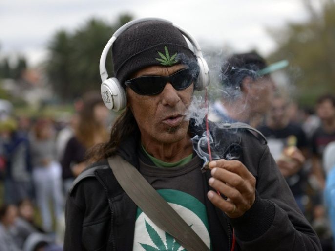 A man smokes a marijuana cigarette at a park where people gathered to mark the First Worldwide March for Regulated Marijuana in Montevideo, Uruguay, Saturday, May 3, 2014. Uruguay released its rules Friday afternoon for the legal marijuana market it is launching this year. In Uruguay, consumers must be licensed, and each purchase will be tracked to ensure they buy no more than 10 grams a week, said Mujica who along with his minister will sign the regulations on Monday, and they'll take effect on Tuesday. (AP Photo/Matilde Campodonico)