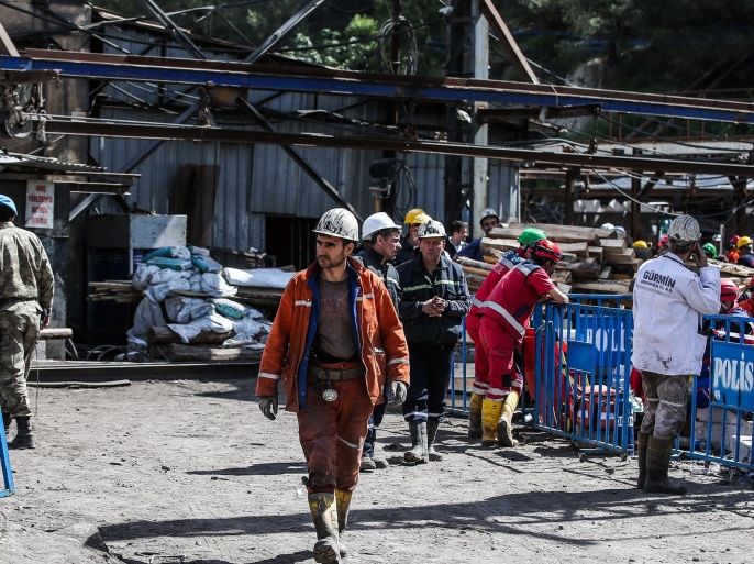 Turkish miners and blue berret troops walk around the entrance of the coal mine in Soma, Turkey, Friday, May 16, 2014. A Turkish mining company defended its safety record Friday, four days after over 250 people died in an underground blaze at its coal mine in western Turkey. (AP Photo/Emrah Gurel)