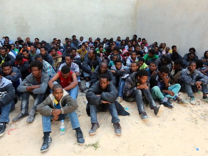 Some of the 340 illegal migrants who were rescued by the Libyan navy off the coast of the western town of Sabratha when their boat began to take on water, sit at a shelter on May 12, 2014 in the coastal town of Zawiya, west of Tripoli. The rescue came on the same day Italy's navy said at least 14 migrants had died when their boat sank between Libya and Italy, the latest in a string of shipwreck tragedies to hit the Mediterranean. Libya has long been a springboard for Africans seeking a better life in Europe, and the number of illegal departures from its shores is rising. AFP PHOTO / MAHMUD TURKIA