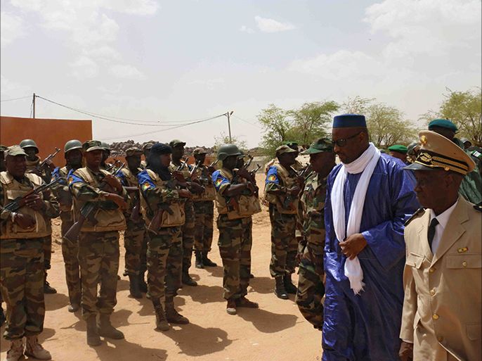 Mali's Prime minister Moussa Mara (2ndR) reviews troops upon his arrival at Kidal, northern Mali, on May 17, 2014, where around 30 civilians and soldiers went missing following clashes between separatist militants and the Malian army in the rebel-controlled northern city of Kidal. The fighting broke out on Saturday outside the building as Mali's Prime Minister Moussa Mara was visiting Kidal as part of his