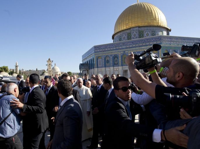 Pope Francis, center, is surrounded by journalists near the Dome of the Rock Mosque, Monday, May 26, 2014. The mosque complex, known to Muslims as the Noble Sanctuary and to Jews as the Temple Mount, is at the heart of the territorial and religious disputes between Israel and its Arab neighbors. Francis has said his three-day Middle East visit is largely meant as a spiritual journey. However, both Israelis and Palestinians have been trying to harness the standing as leader of the world's Roman Catholics to bolster their dueling narratives. (AP Photo/Ariel Schalit)